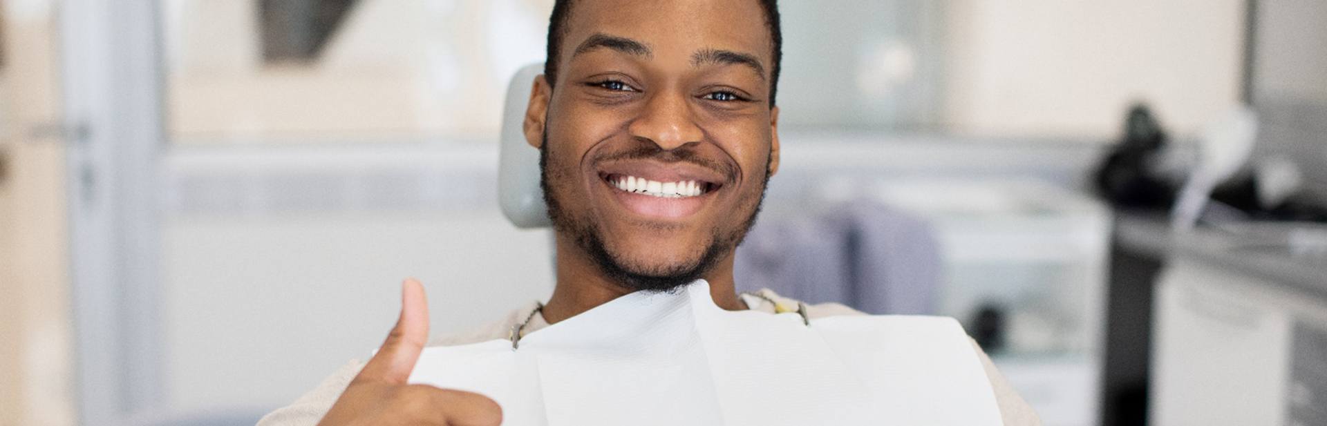 Male dental patient giving a thumbs up