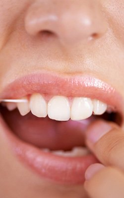 woman flossing teeth