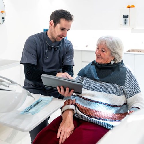 Senior patient conversing with her dentist
