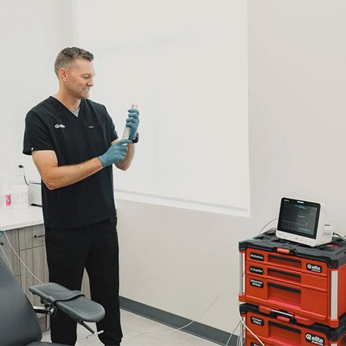 a dentist in black scrubs in a dental office