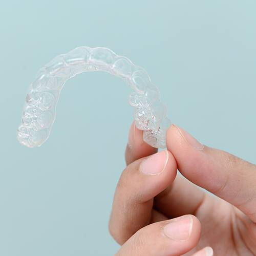 Closeup of patient holding clear aligner