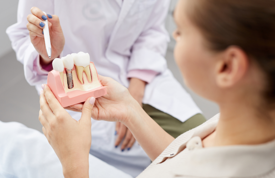 Dentist showing patient model dental implant